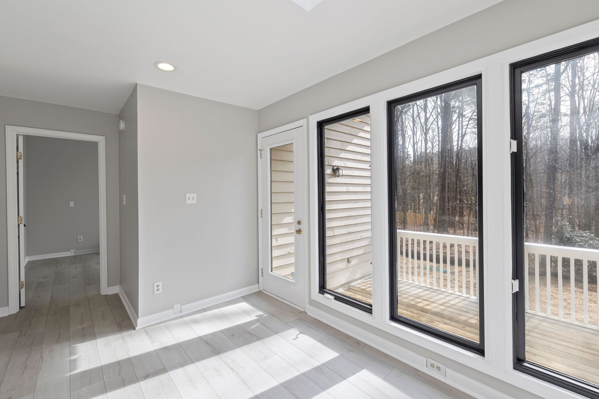 Spacious and bright room with large glass windows overlooking a serene outdoor setting.